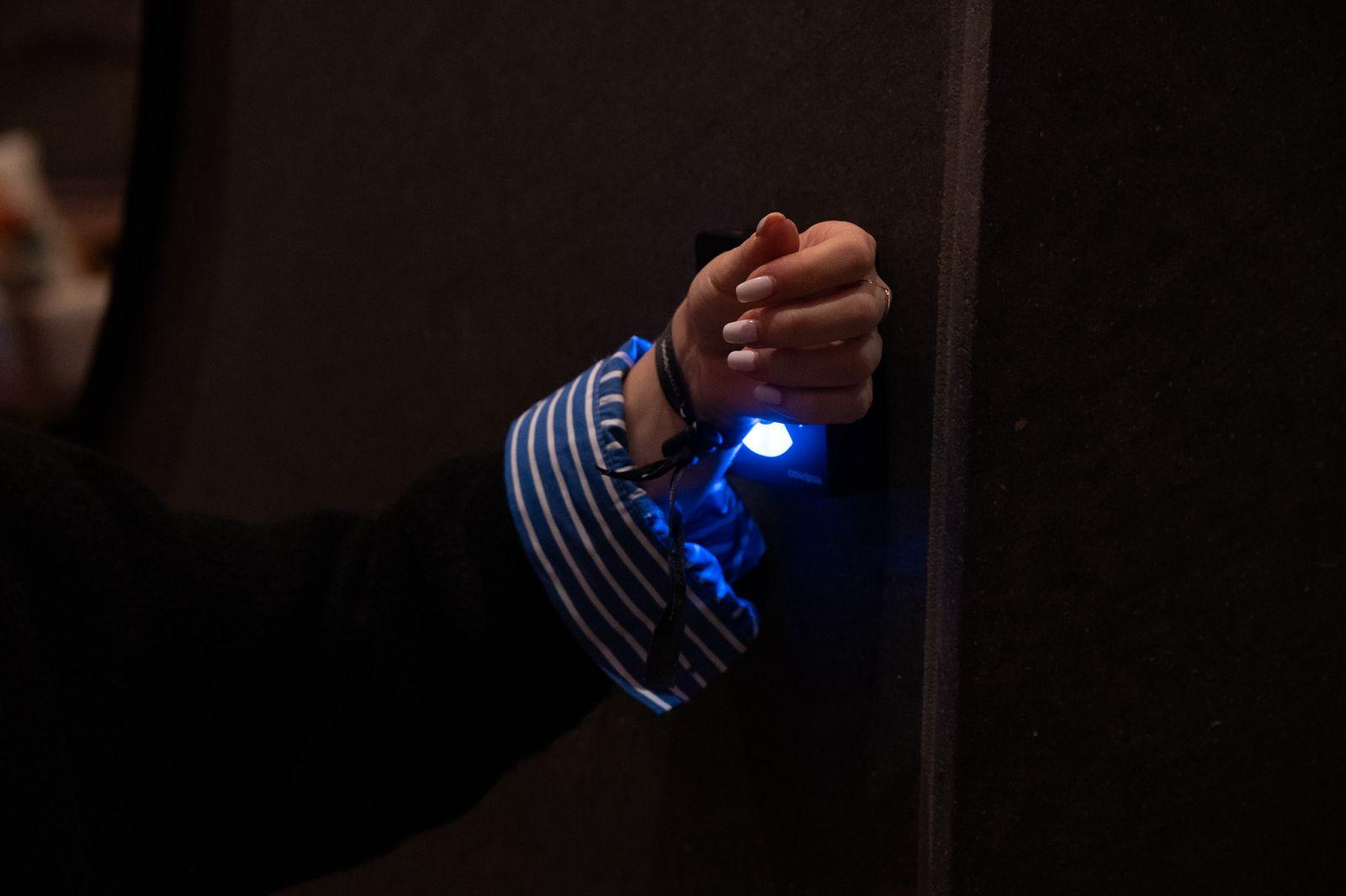 Guest tapping NFC wristband on reader for event check-in